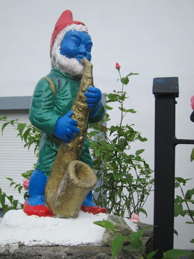 Random Papa Smurf playing saxophone statue outside of someone's house